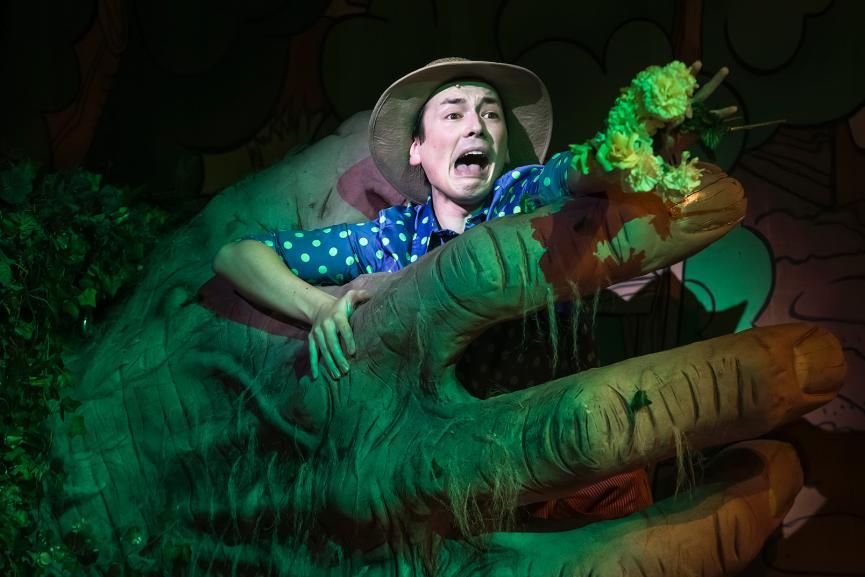 Jack wearing a straw hat in the hands of the giant