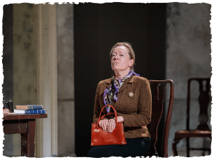 a woman in a brown jacket sitting on a chair