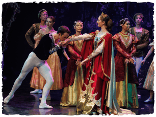 Performer in black and white dances alongside a performer with red and gold robes