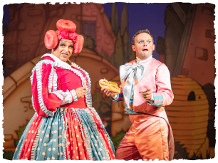 Panto dame and comic character wearing colourful clothes and pulling funny faces at the camera