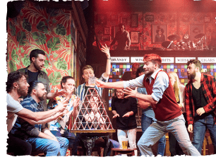 Men stacking cards in big traingle; looking panicked that it may collapse