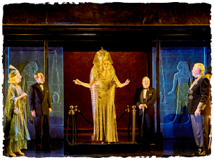 Actors in front of a sarcophagus