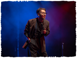 A man on stage in a black suit