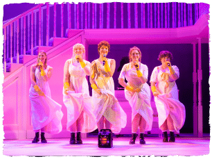 4 actors in white dresses holding microphones