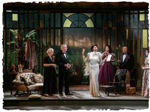 A group of people at a lavish party, one lady in a silver dress centre stage