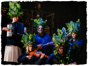 People disguised as hedges, playing instruments