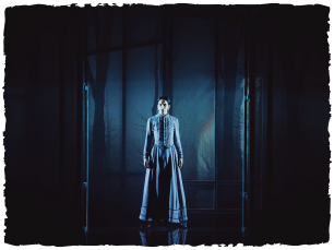 A woman stood on empty stage, blue lights