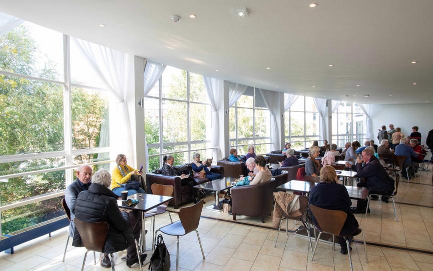 A group of people sitting in the Circle Bar - a large open room with large windows
