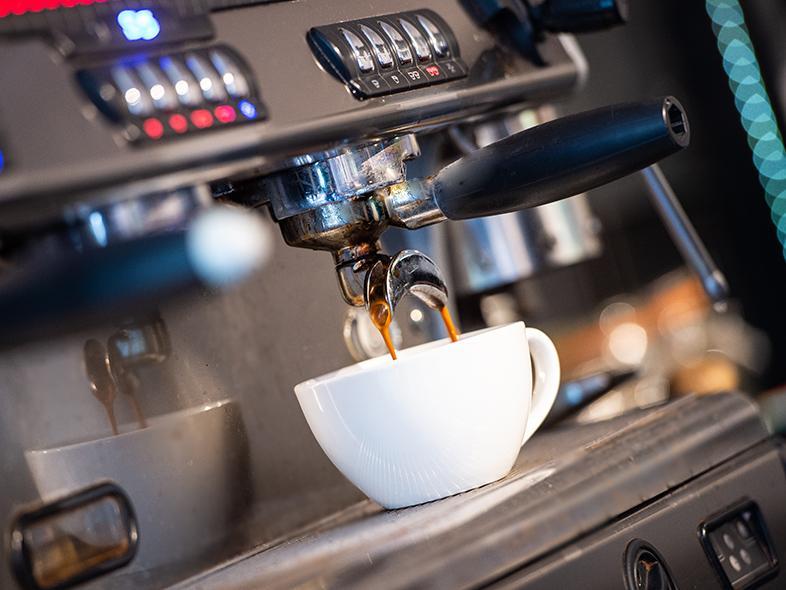 An espresso cup sits on a coffee machine
