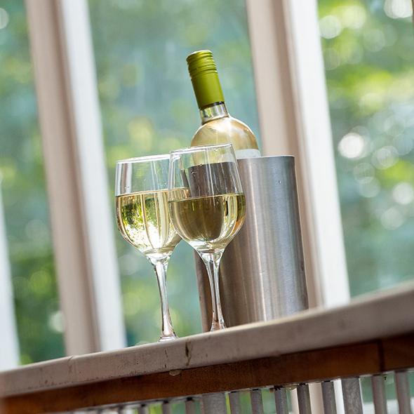 A bottle of white wine and two half-filled glasses stand on the stalls bar at the Yvonne Arnaud Theatre