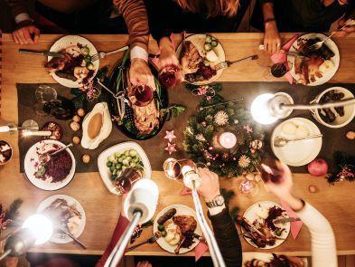A Christmas Meal on a wooden table with glasses of wine