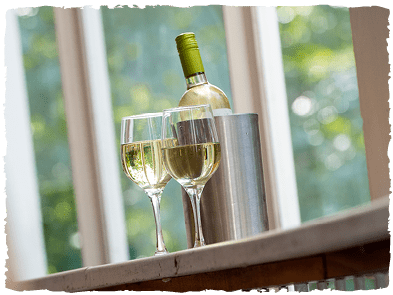 A bottle of white wine and two half-filled glasses stand on the stalls bar at the Yvonne Arnaud Theatre
