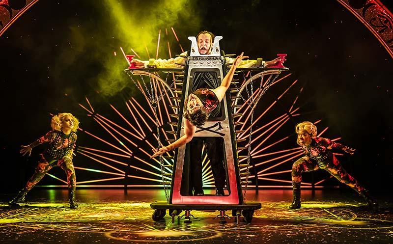 A group of magicians stand on a large stage.