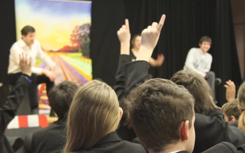 A group of school children holding up their hands.