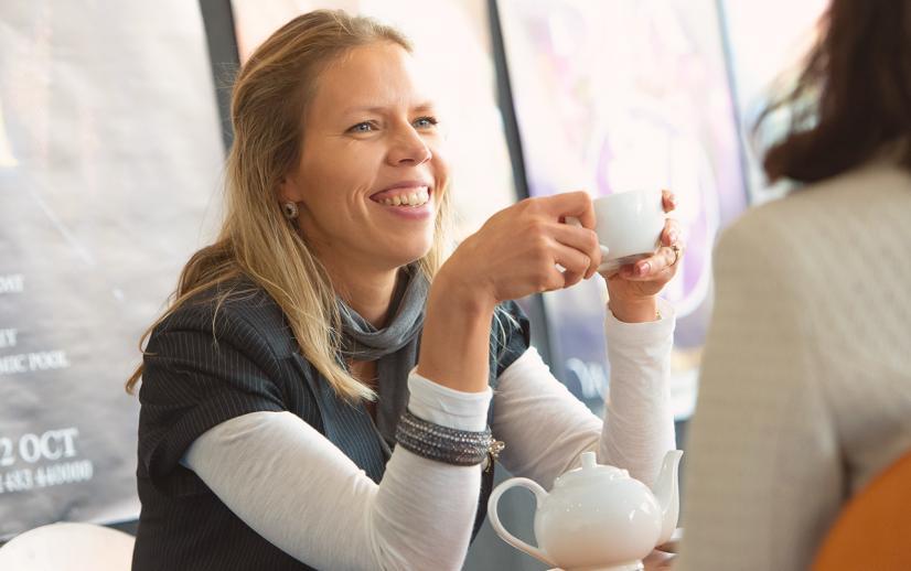 A woman enjoys a cup of tea in the Yvonne Arnaud Cafe