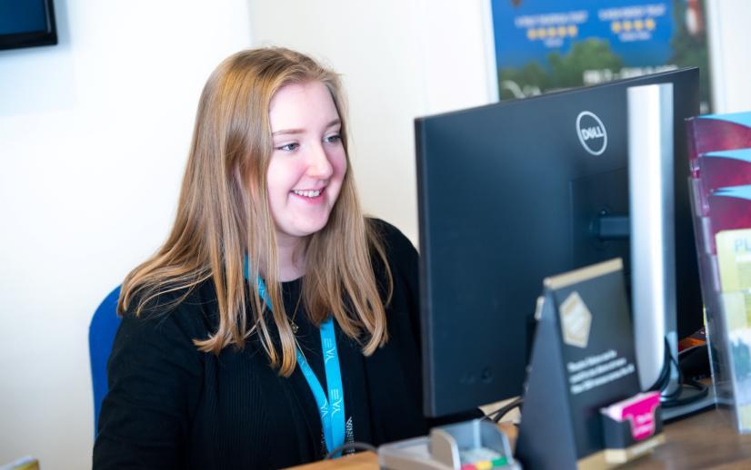 A woman smiles at a screen at box office