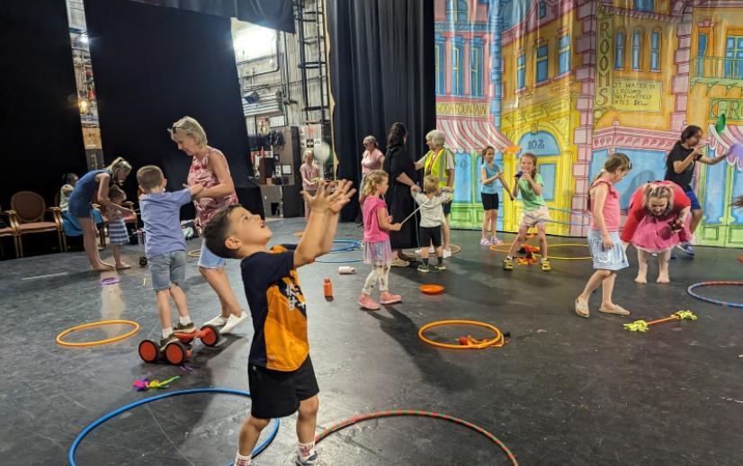 Children playing at a circus workshop with hula hoops
