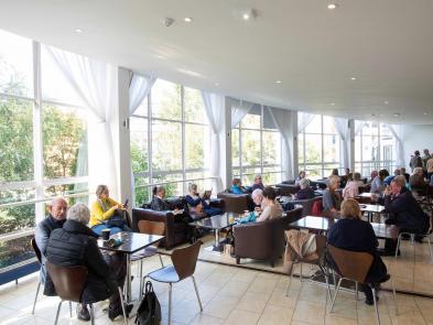 A group of people sitting in the Circle Bar - a large open room with large windows