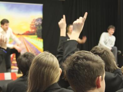 A group of school children holding up their hands.