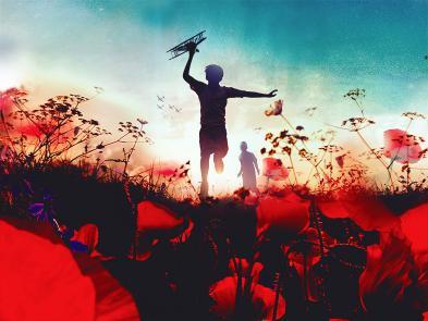 A silhouette of a young boy running through a poppy field holding a small toy aeroplane. 