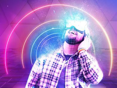 A man in a check shirt is wearing a virtual reality headset over his eyes. Around him is a rainbow of neon lights