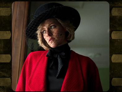 An actress playing princess Diana in a red suit and a black hat looks out of a window.