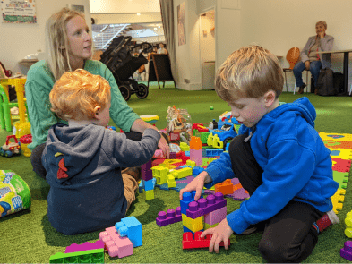Children and parents playing with colourful brick toys