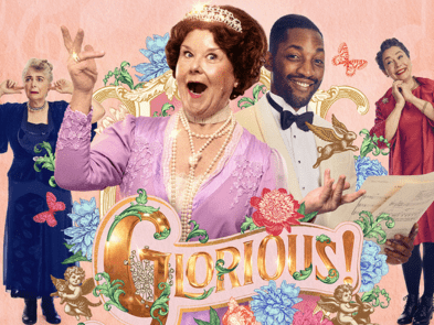 A woman with brown hair and a tiara wearing a pearl necklace and a pink top is singing in front of a pink background with an ornate golden frame, with a smiling man and woman next to her and one woman with her fingers in her ears