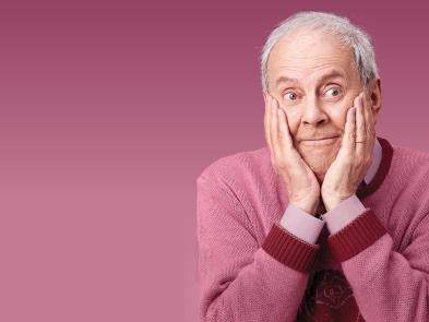 Gyles Brandreth in pink jumper, with pink background