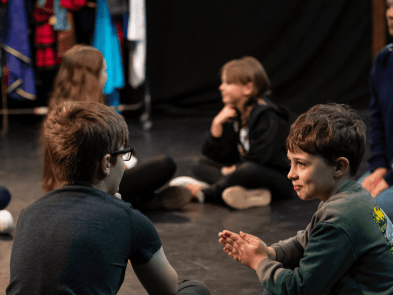 Children taking part in a workshop sitting in a circle 