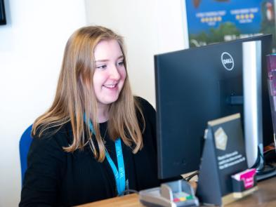 A woman stares at screen smiling at Box office